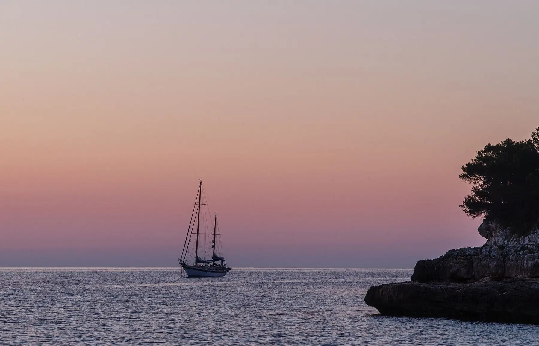 A ketch crossing the bay at dusk
